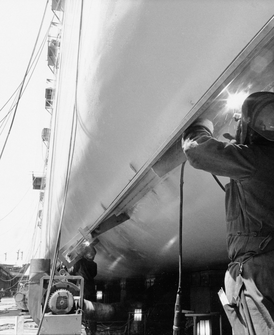 Soldador a trabalhar no casco de um navio em estaleiro naval